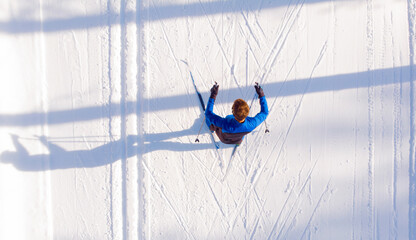 Skier cross-country skiing in snow forest. Winter competition, Aerial top view - obrazy, fototapety, plakaty
