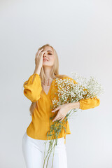 a young girl with beautiful makeup with white flowers on a gray background. blogger