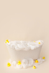 White small bath for a photo shoot of a child on a light background, decorated with ducks.