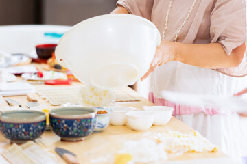 Fototapeta na wymiar 料理教室で巻き寿司を作る女性の手元