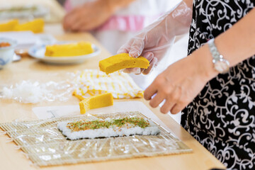 料理教室で巻き寿司を作る女性の手元