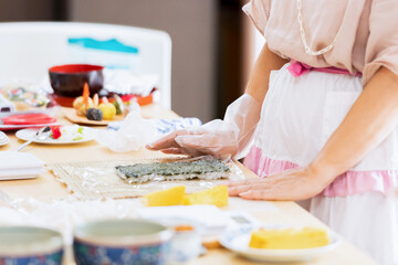 Obraz na płótnie Canvas 料理教室で巻き寿司を作る女性の手元
