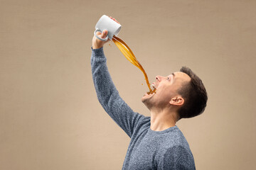 Man pouring a jet of coffee straight into his mouth