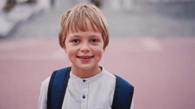 Portrait of 8 year caucasian boy looking to the camera and smile with dimples on cheeks.