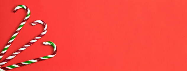Minimalist composition of Christmas sweets on a red background. Banner.