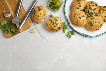 Traditional Ukrainian bread (Pampushky) with garlic on light grey marble table, flat lay. Space for text