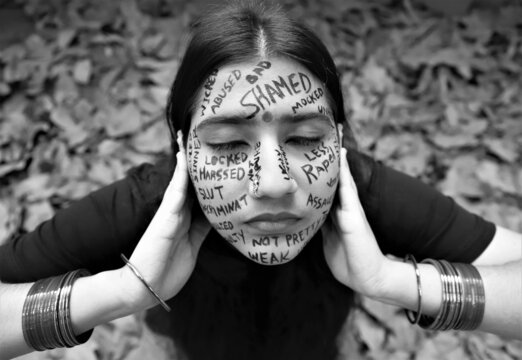 A young woman raising awareness for  International day for the elimination of violence against women by writing a anti violence messages all over her face