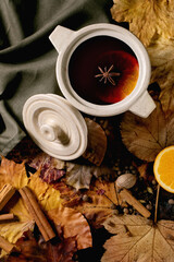 Fototapeta na wymiar Hot mulled wine with spices and autumn leaves
