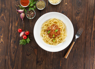 Spaghetti bolognese pasta with tomato sauce and minced meat, parmesan cheese and fresh basil - homemade italian pasta on rustic wooden background. Top view with ingredients, cooking at home concept