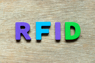Color alphabet letter in word RFID (Abbreviation of Radio-frequency identification) on wood...