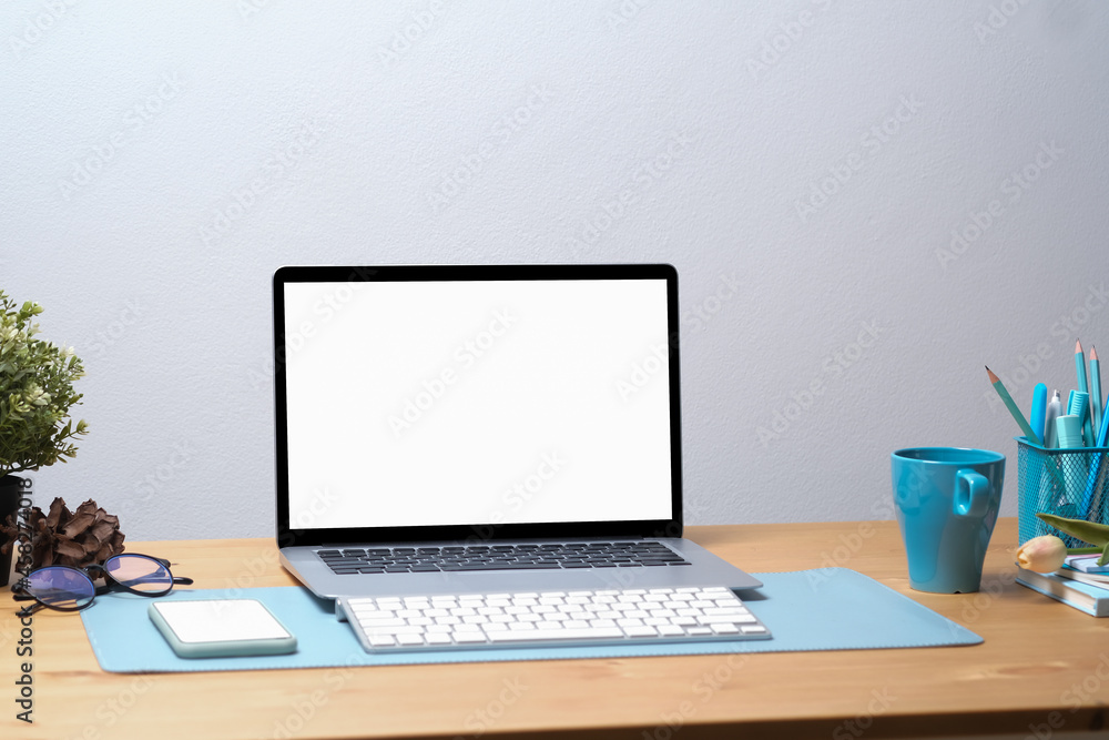 Poster photo of an empty screen computer laptop with a wireless keyboard putting on a wooden table surround