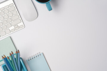 Top view copy space with coffee cup, wireless mouse, pencil holder, keyboard, and notepad.