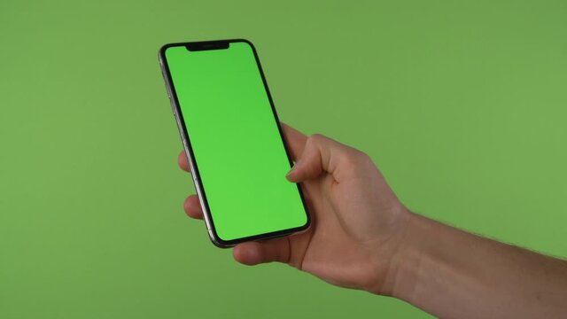 Hand swipes to accept call on phone with chroma green in front of green screen