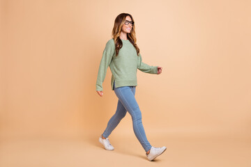 Fototapeta na wymiar Full length body size photo woman wearing glasses casual outfit walking isolated pastel beige color background