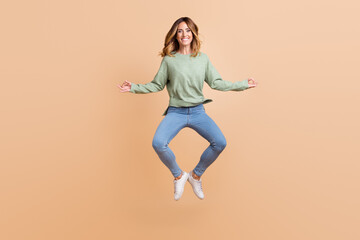 Fototapeta na wymiar Full length body size photo woman jumping meditating in yoga pose isolated pastel beige color background