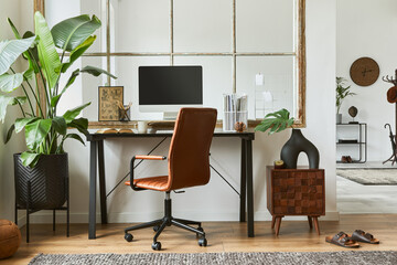Fototapeta premium Stylish composition of modern masculine home office workspace interior design with black industrial desk, brown leather armchair, pc and stylish personal accessories. Template.