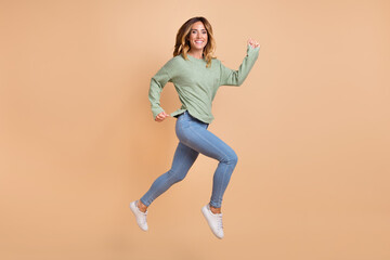 Fototapeta na wymiar Full length body size photo woman jumping high running cheerful happy isolated pastel beige color background
