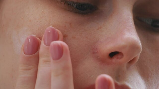 Woman closeup applying an organic face skincare nourishing cosmetic creme. Facial beauty treatment. Spa procedure. Macro female beautiful face.