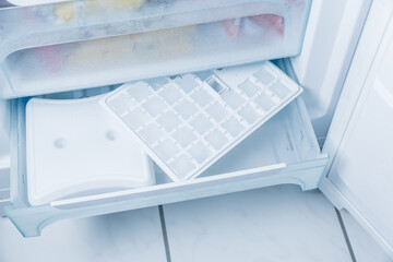 Ice cube maker in modern freezer - obrazy, fototapety, plakaty