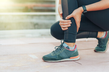An athlete holds on to her injured leg on treadmill