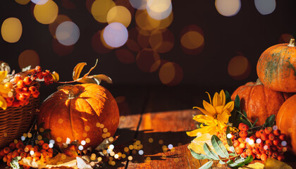 Pumpkins with yellow leaves and flowers on wooden background