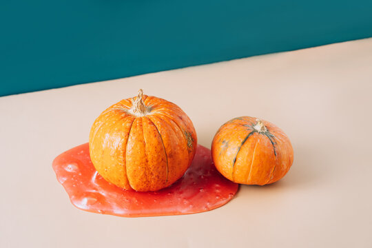 Two Beautiful Orange Pumpkins On Red Slime