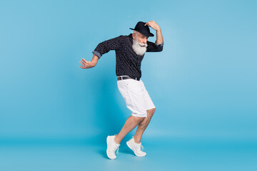 Full length photo of funny funky happy man dance hold hands hat funky isolated on pastel blue color...