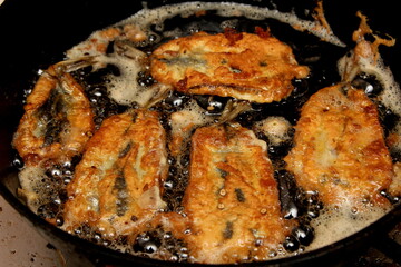 Small fish fry in a pan. Fried fish in a frying pan. Small crispy fish are fried in oil. 