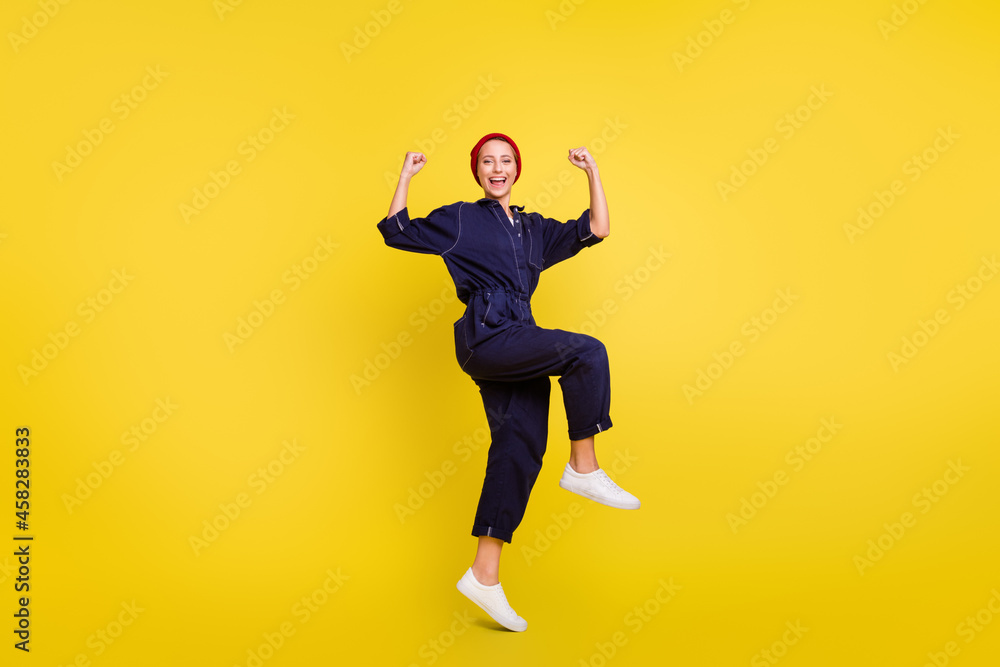 Wall mural Full length body size view of attractive cheerful lucky girl jumping rejoicing isolated over bright yellow color background