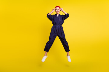 Fototapeta na wymiar Full length body size view of attractive cheerful girl jumping having fun rest isolated over bright yellow color background