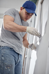 Young adult man working on a DIY budget renovation of his new home apartment.