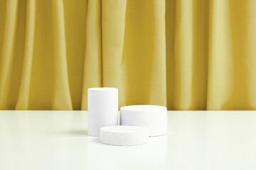 Podiums or pedestal Mock-up with leaves for cosmetic production on a golden background with folds of fabric.