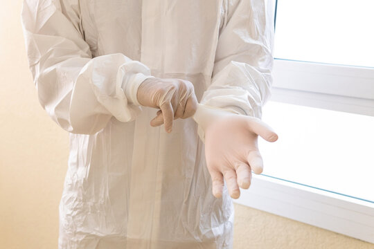 Faceless doctor putting on sterile gloves in clinic
