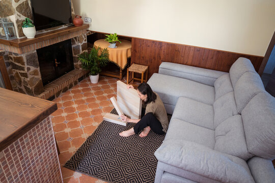 Asian woman assembling table in living room