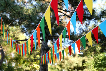 Colorful bunting flags in park. Party decor