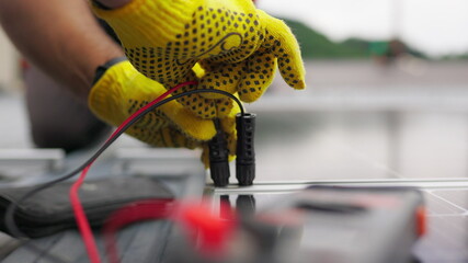 Close up, Solar energy specialist monitoring solar panels with his multimeter. Alternative, green...