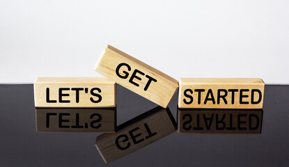 let's get started text on wood block and black and white background. business concept