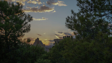 Naklejka premium Atardecer con tonos amarillos, nubes y la silueta del edifico de la pirámide en Alicante