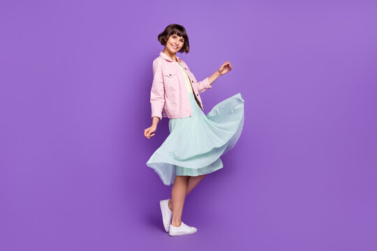 Full size photo of young positive cheerful woman wear skirt wind blow casual enjoy isolated on violet color background