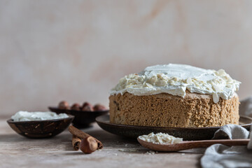 Homemade sponge cake or biscuit with nuts and spices decorated with butter cream or cream cheese icing.
