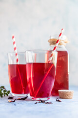 Hot hibiscus or karkade tea in glass with herb and dry tea leaves. Vitamin herbal tea for cold and flu.