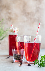 Hot hibiscus or karkade tea in glass with herb and dry tea leaves. Vitamin herbal tea for cold and flu.