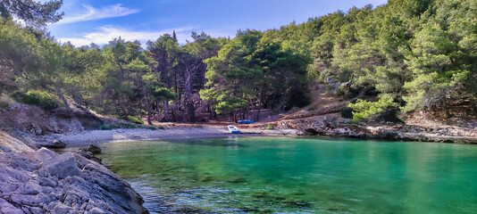 View of the sea coast and beach Kašjun on the island of Šolta. The boat in the bay in the adriatic sea. Trees in the hills. Dalmatia. Croatia. Europe - obrazy, fototapety, plakaty