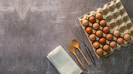 Fototapeta na wymiar Eggs and egg whisks,Top View three eggs in glasses bowl, blurred eggs in wicker basket and egg beater on the floor, preparing preparing for cooking food or dessert, copy space
