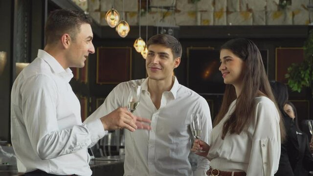 Group of corporate people drinking champagne and discussing at the company party. business meeting conference or  New Year party. colleagues enjoy talking together