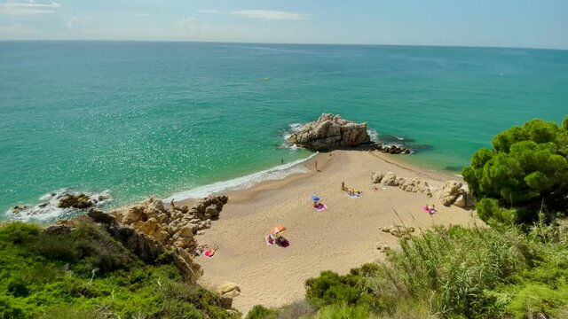 Cala Roca Grossa  sunny summer day mediterranean european tourism Paradise beach aerial view from drone contrast with rock sand and green trees barcelone spain Costa brava