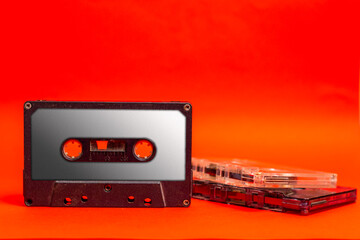 Compact cassette. Audio cassette or compact cassette b on an orange background. Previously, it was...