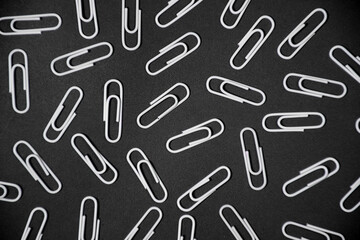 Paper clips backgorund. white paperclips on black background