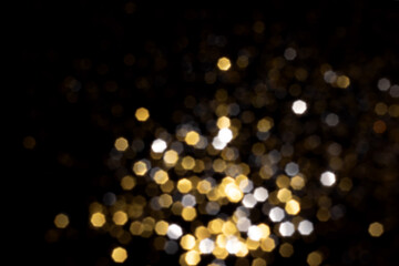 Golden and silver blurred bokeh lights on black background. Glitter sparkle stars for celebrate....