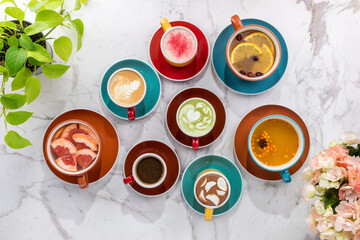 Different types of hot drinks coffee, matcha, cocoa and tea on marble background